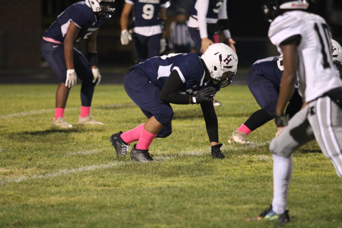 Football player gets set on defensive before the Turner Ashby Knights snap the ball.