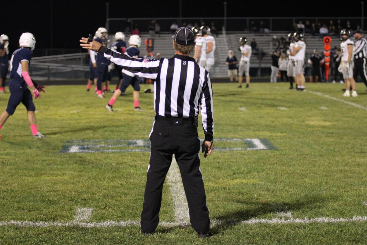 The referee prepares for the Blue Streaks to run a play.