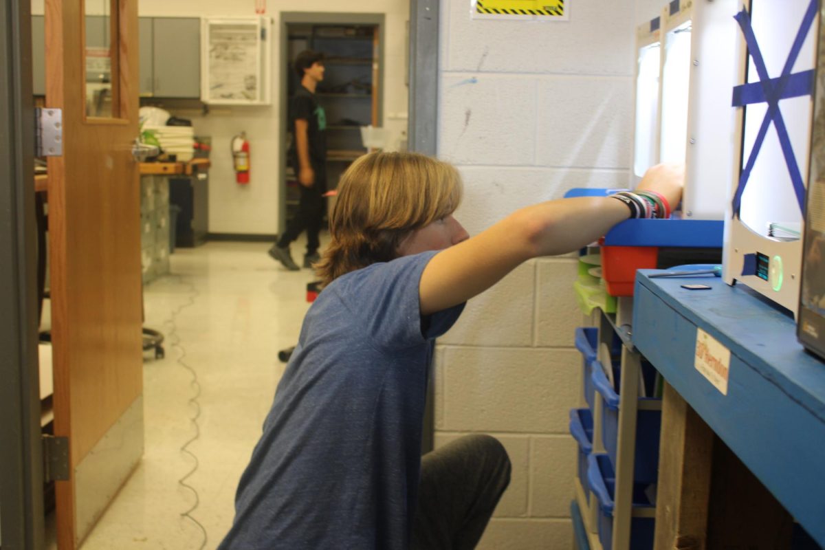 Luke Showalter is checking in on the progress that the 3D printer has done