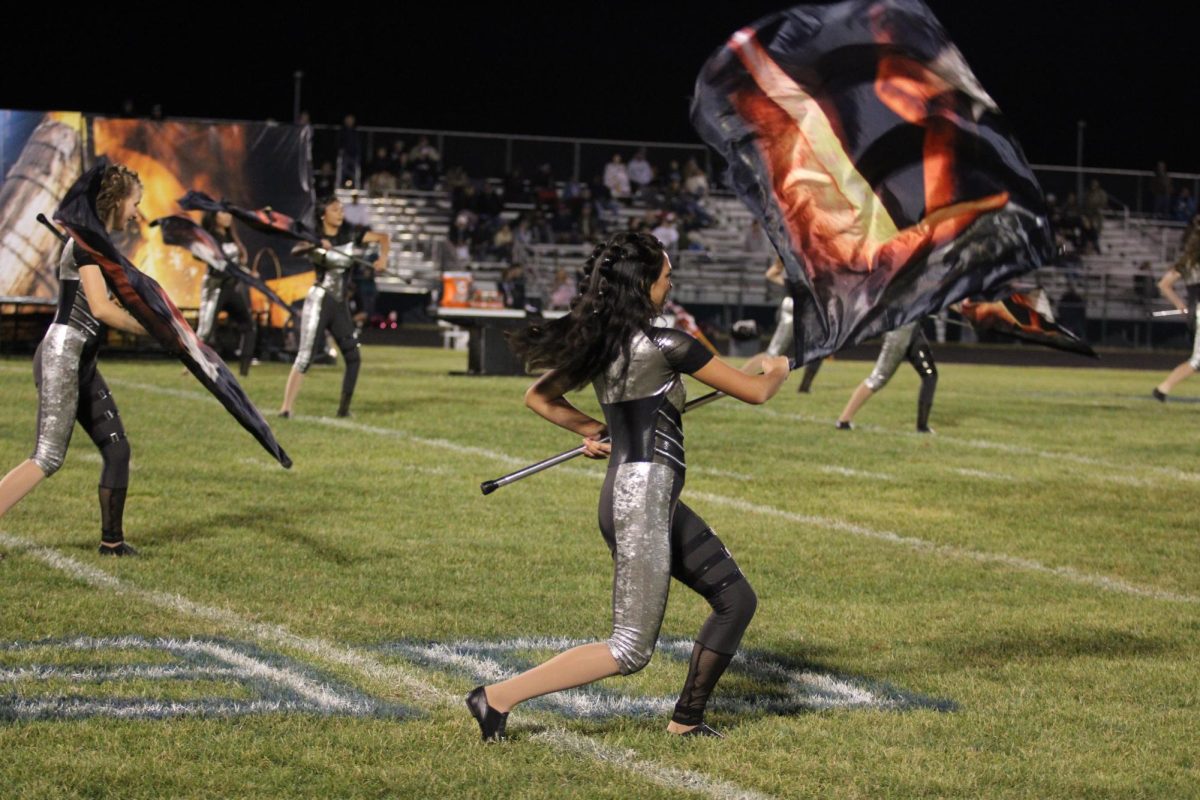 Susy Syharath dances with the color guard. 