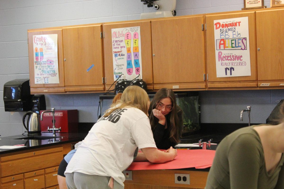 Grace Tuysinger working on poster for homecoming with friends.