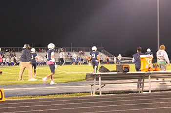 Football players walking on the field.