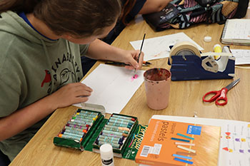 Sophomore Alonzo Vaughan Is painting an ombre circle with water colors.