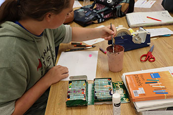 Sophomore Alonzo Vaughan Is painting an ombre circle with water colors.