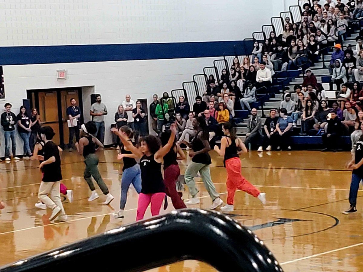 HHS dance runs out onto the gym floor, flaunting their black tops and colorful pants!