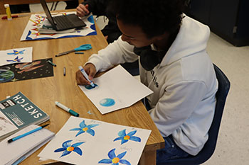 Sophomore Angel Andujar is drawing an ombre circle with crayons.