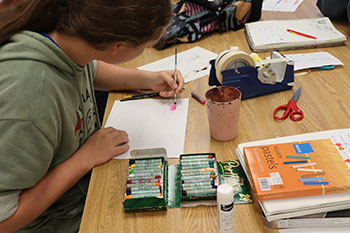 Sophomore Alonzo Vaughan Is painting an ombre circle with water colors.