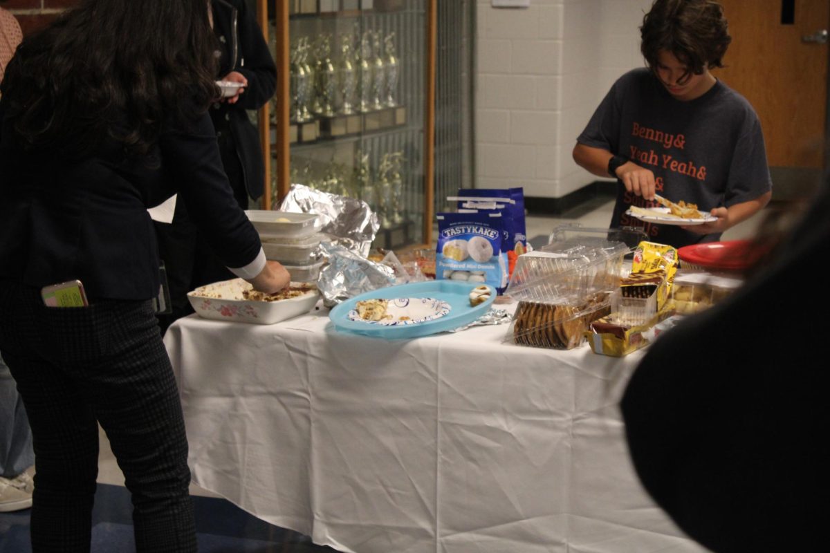 Many people enjoying the different types of pastries.