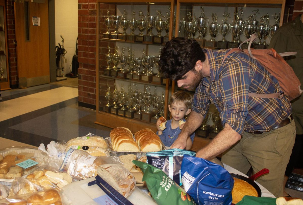 Trevor Chase, Biology teacher at RHS, cutting bread for students.