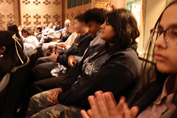 The Debate team watching the awards ceremony, eagerly awaiting their placements.
