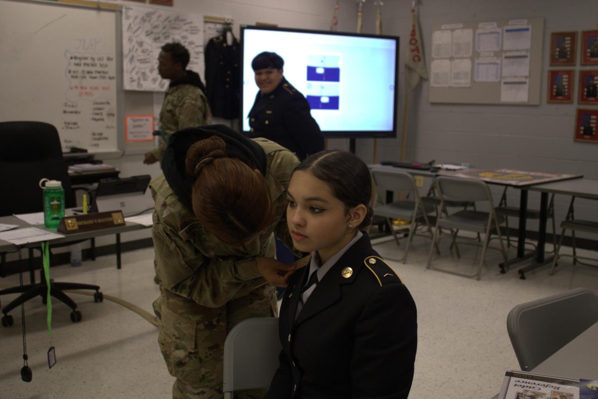 C/1SGT Elana helping out C/CPL Gabi with uniform before inspection