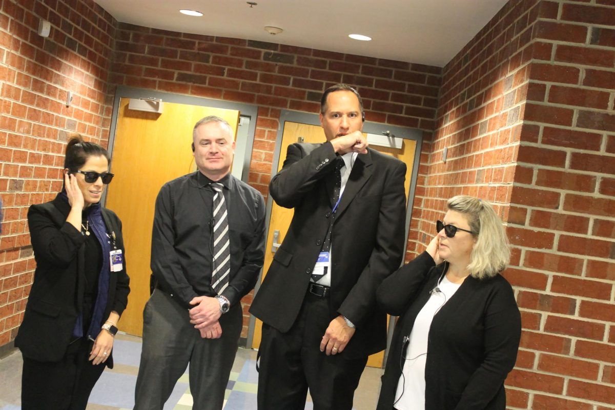 Group photo of staff members doing the 007 spy pose.
