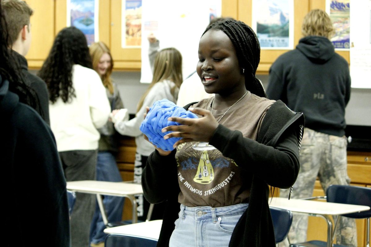 Rocktown STEM student inspects her teams recently constructed pyramid made from sculpting putty.