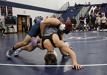 Senior wrestler Izaack Cruz on top of his opponent.