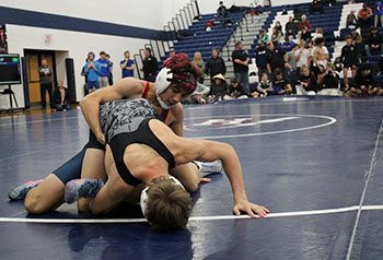 Senior wrestler holding down his opponent.