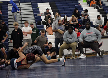 Harrisonburg Coach White watching senior wrestler Izaack Cruz.