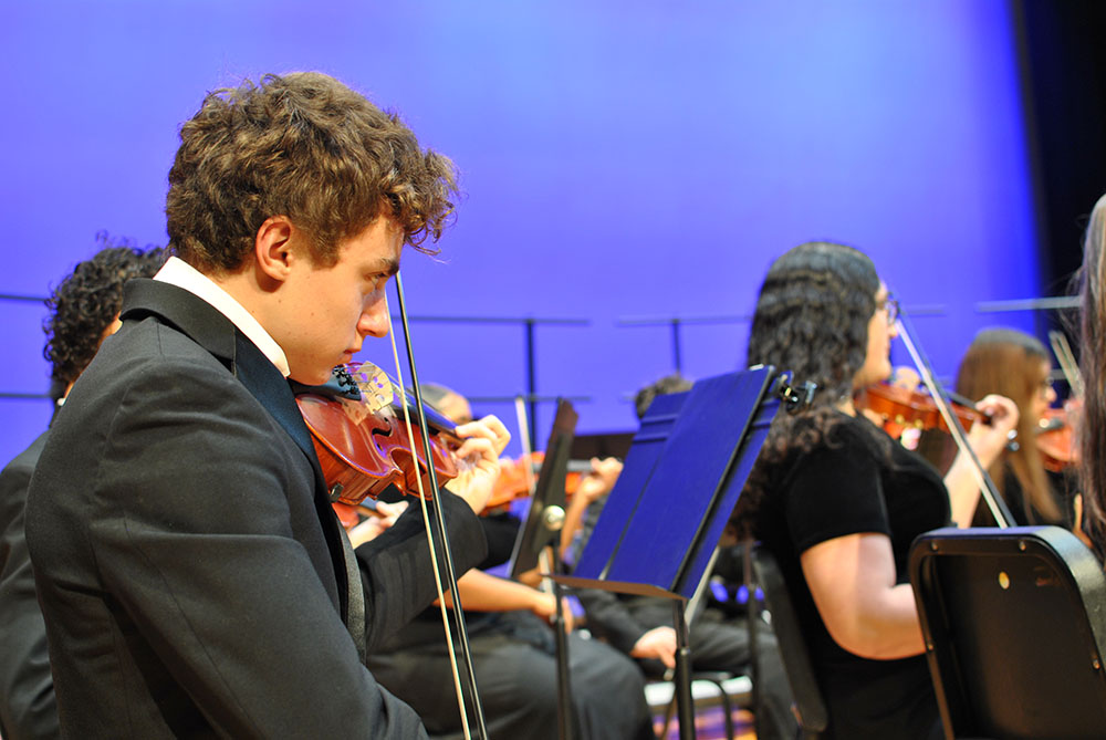 A boy plays a violin.