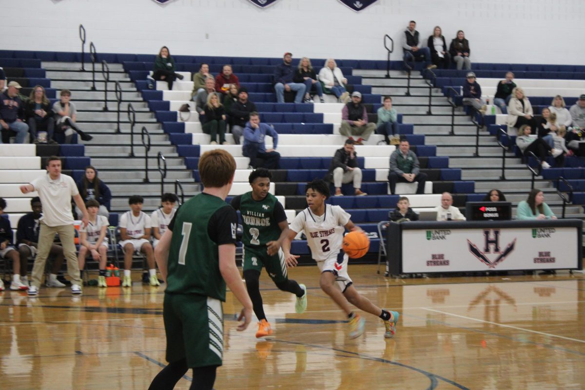 Jacquez Williams passes by the other team trying to get to the other side without getting the ball taken from him. Williams dribbles the ball as he makes his way past the other team.