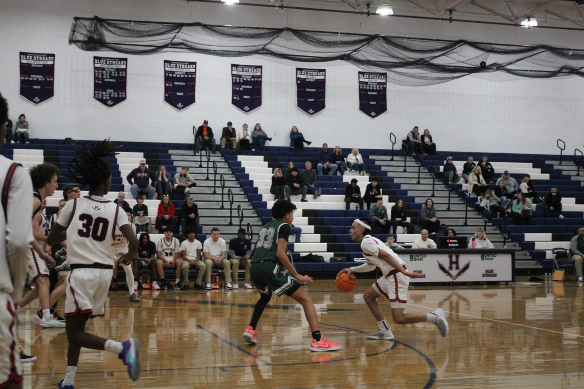 Lazaro Valdivia Arrillaga crosses the other school's basketball players with only a few other players left to pass. Valdivia advances towards his teammates to pass the ball and make a shot.