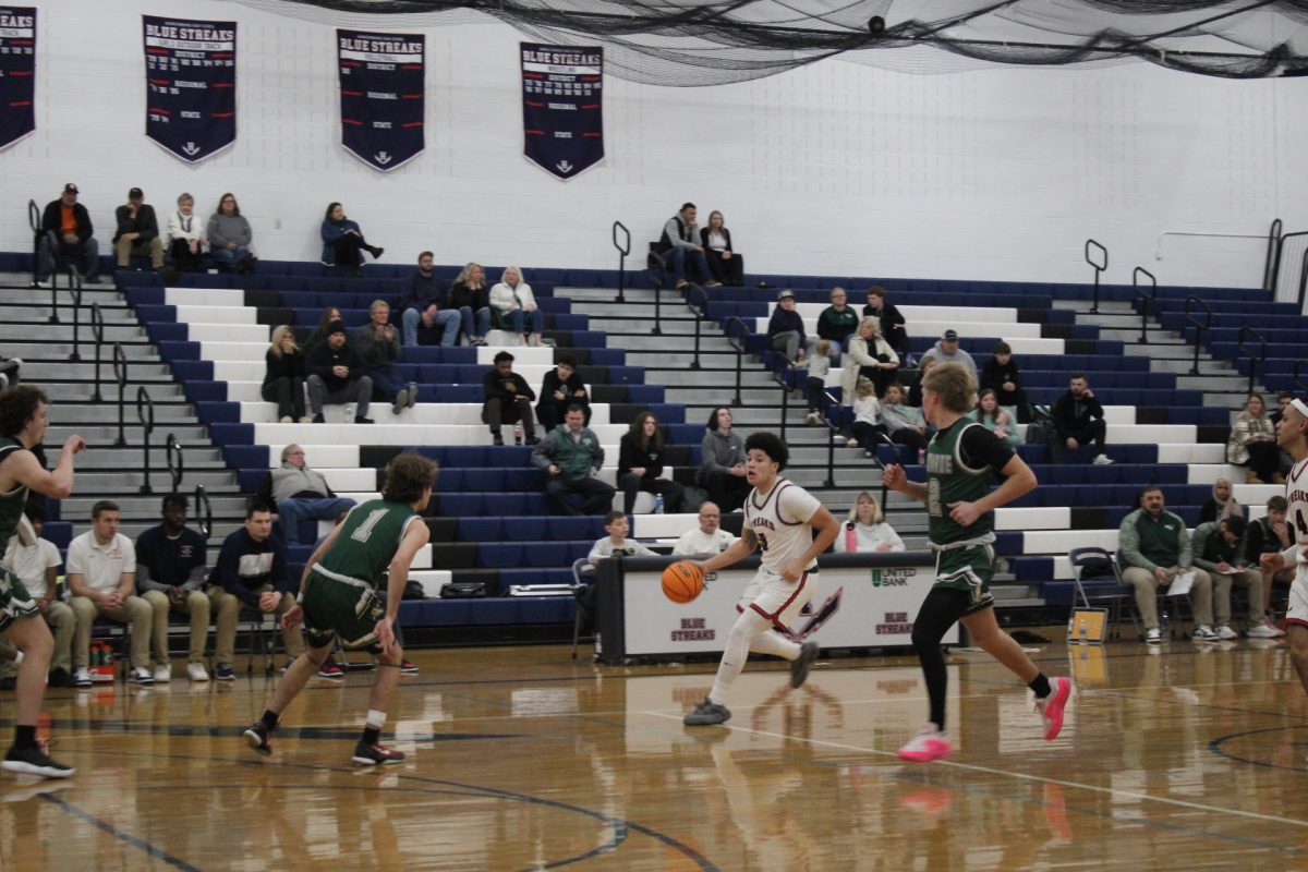 Yandel Robles does his best to try and avoid any of the opponents. Robles dribbles the ball across the court and tries to find anyone who may be open to pass the ball.