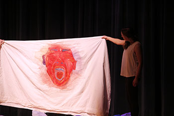 Junior Ella Horst showing her art piece that she made which was showed and expressed in Sylvia Young's dance at the HHS Fine Arts Showcase tuesday night.