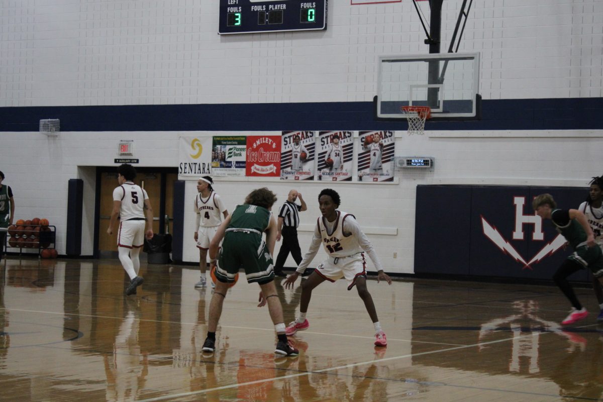 Merhowe Gebrenegus focuses on the other team’s position on the court. The Harrison burg basketball team does their best to defend and take back the ball.