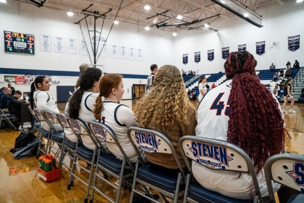 Eman Akotiate, Leah Crawford, Ava Colley, and Kayli Alvarado watching the basketball game.