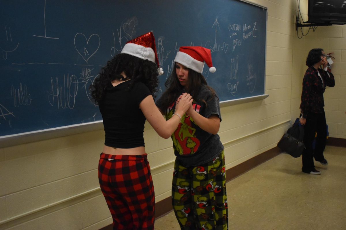 Freshman Lilith-bell and Freshman Aliana dance salsa as they wait for the activities to starts. 