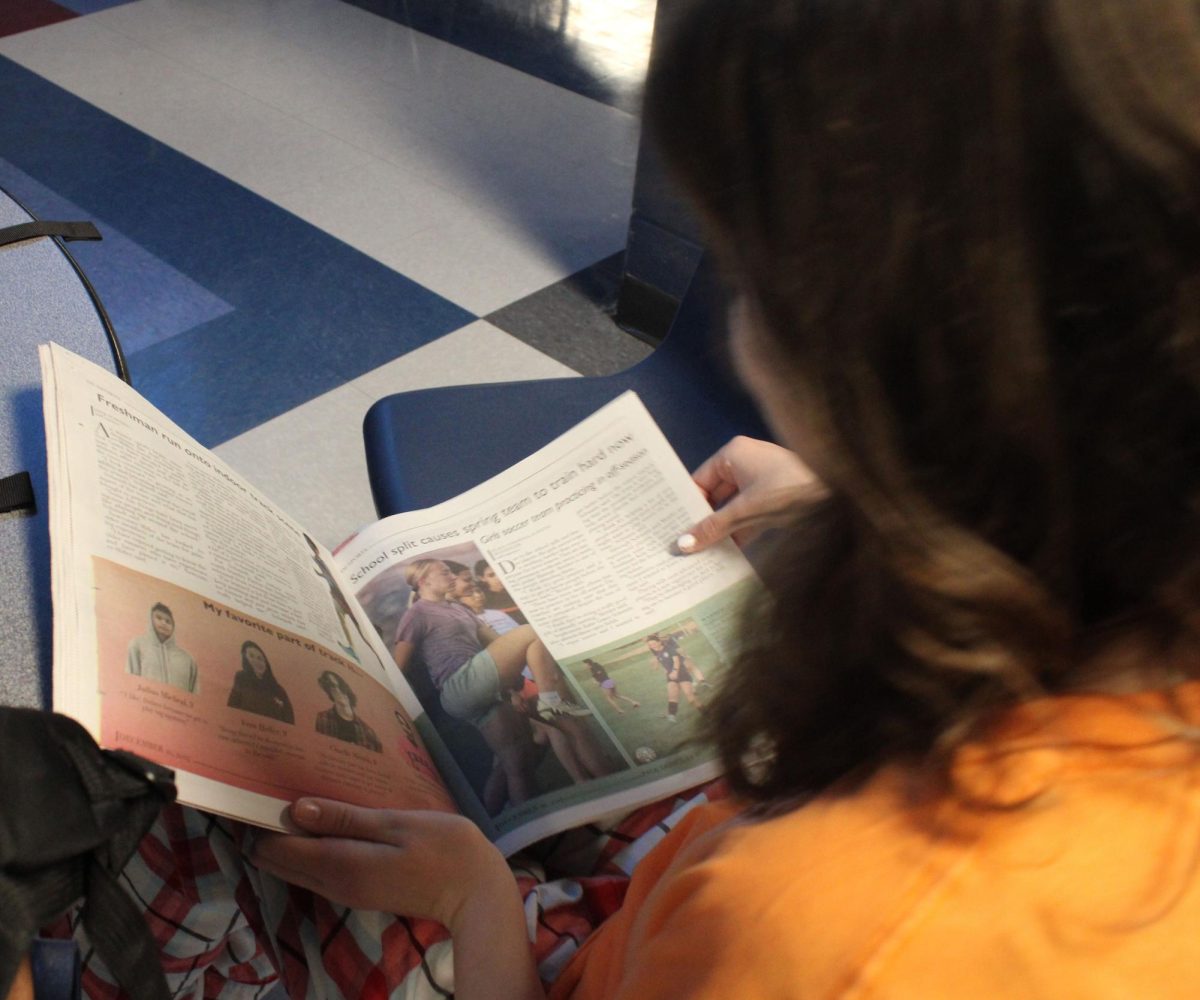 Freshman Fiona Huffman reading the newspaper