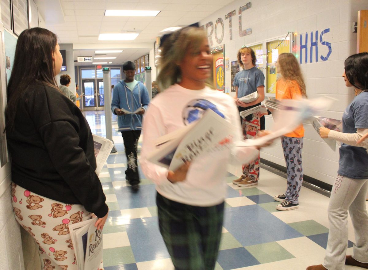 HHS student excited with multiple newspapers