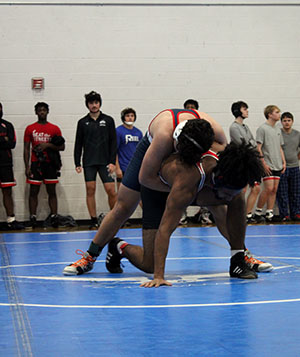 Freshman Enrique Hernandez Erazo holding onto a crouching opponent.
