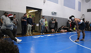 Wrestling Coach White coaching freshman Enrique Hernandez Erazo.