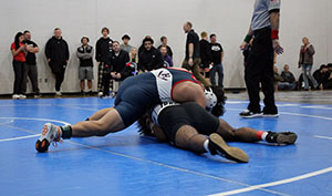 Freshman Enrique Hernandez Erazo holding his opponent while on top of him.