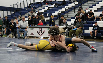 Mason George pushing his opponent onto the ground.