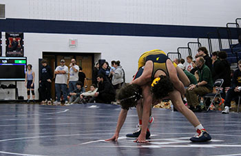Freshman Mason George squatting with his opponent on top of him.