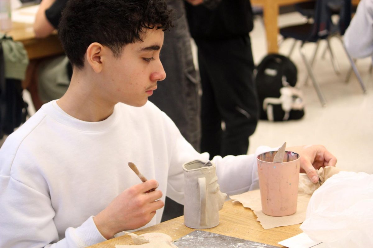 Student completes face mug.