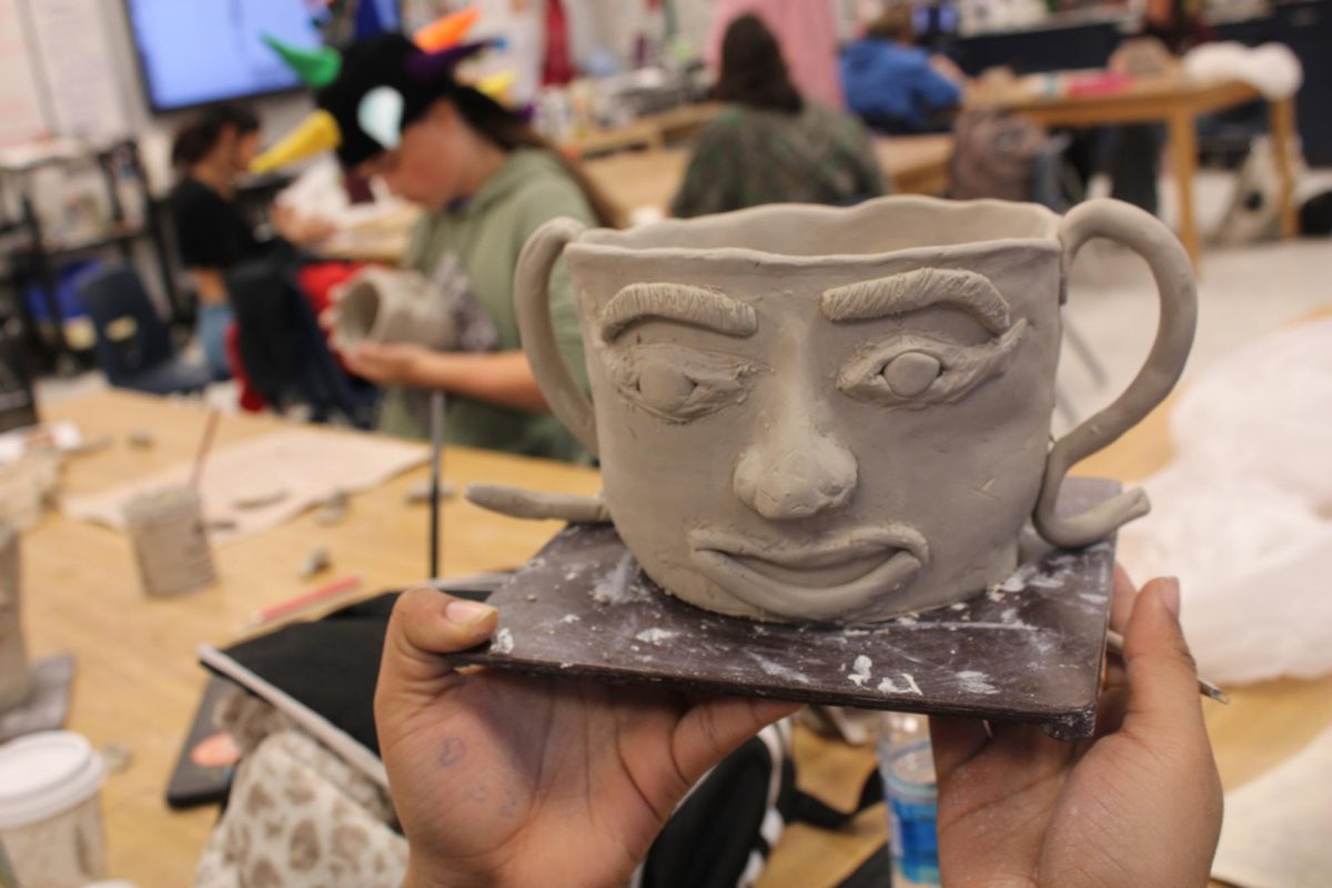 student shows their mug.