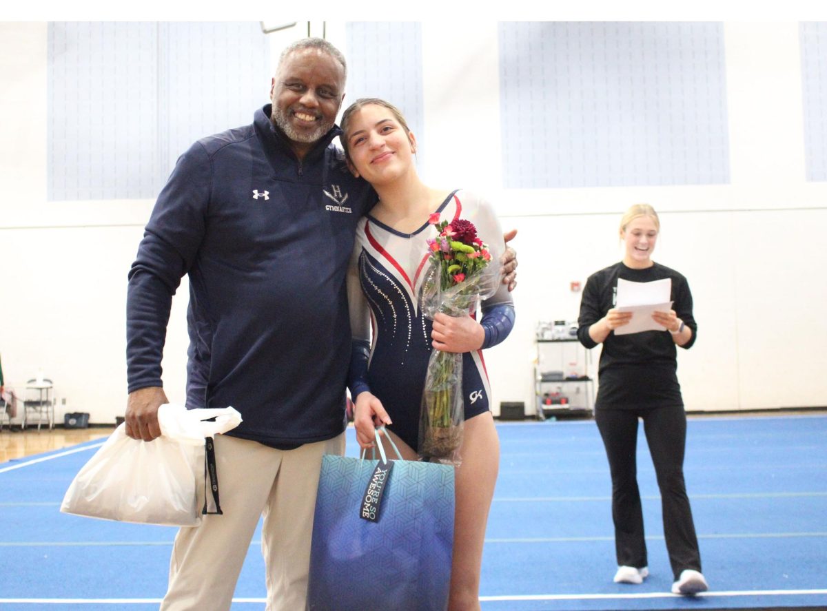 Senior Michelle Segarra stands with the HHS gymnastics coach for senior night.