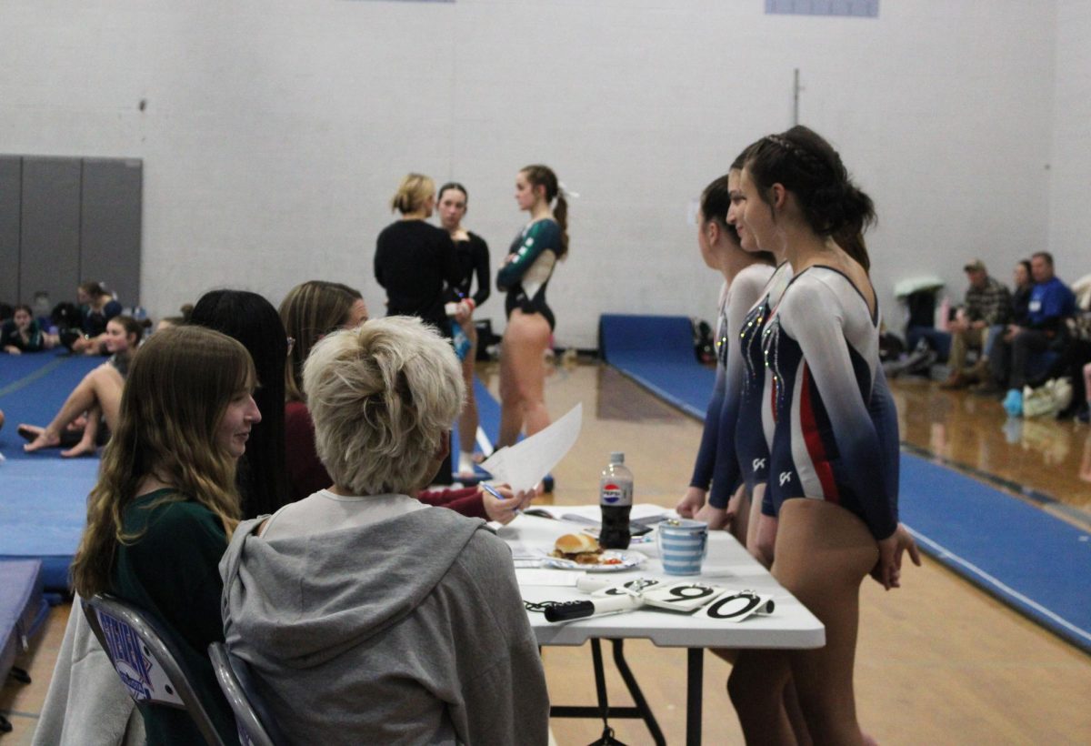 The HHS gymnastics team talks with the student judges.