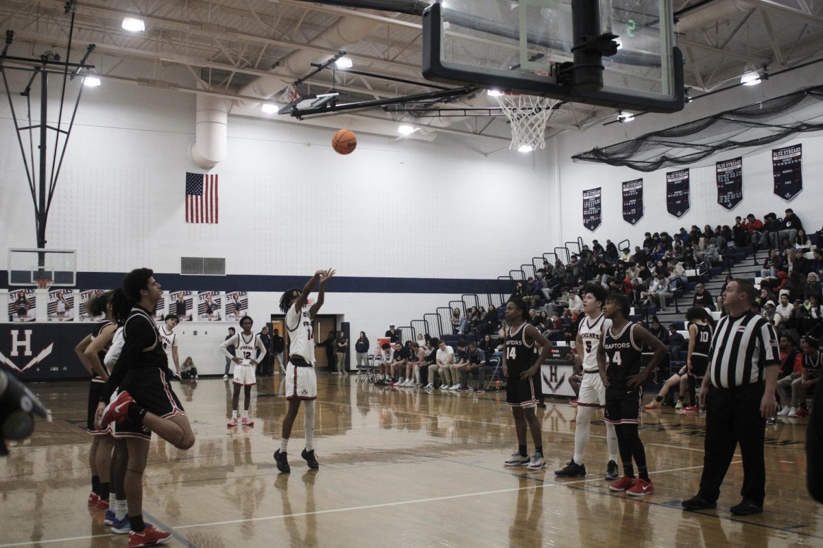 Mordecai Embaye shoots the basketball while the rest of the teammates wait