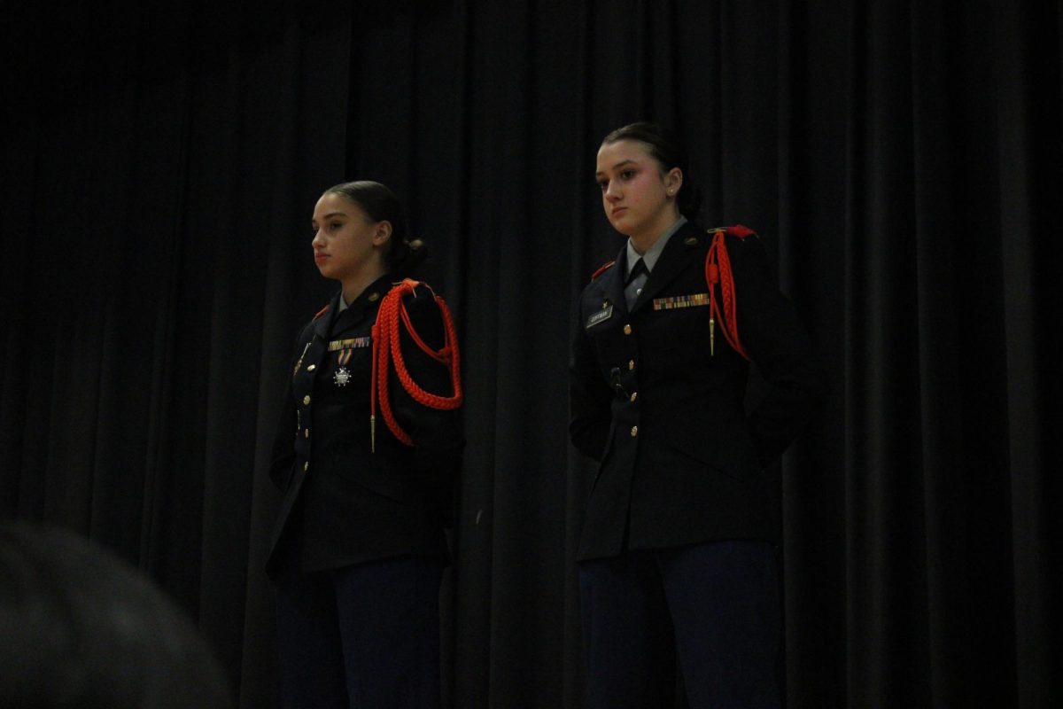 Freshman Rachel coffman and Freshman Lucy Hunter stand and show the eighth graders there uniforms.