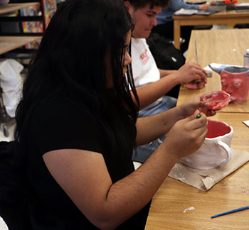 Stephenie Acosta glazing her "ugly mug" project.