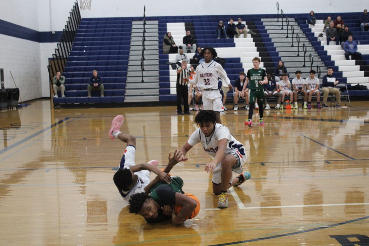 Pierre Ngeleka falls to the ground along with a student on the other team. Jacquez Williams sees an opportunity and quickly tries to take back the basketball. The referee decides to blow the whistle in order to solve the situation and move on.