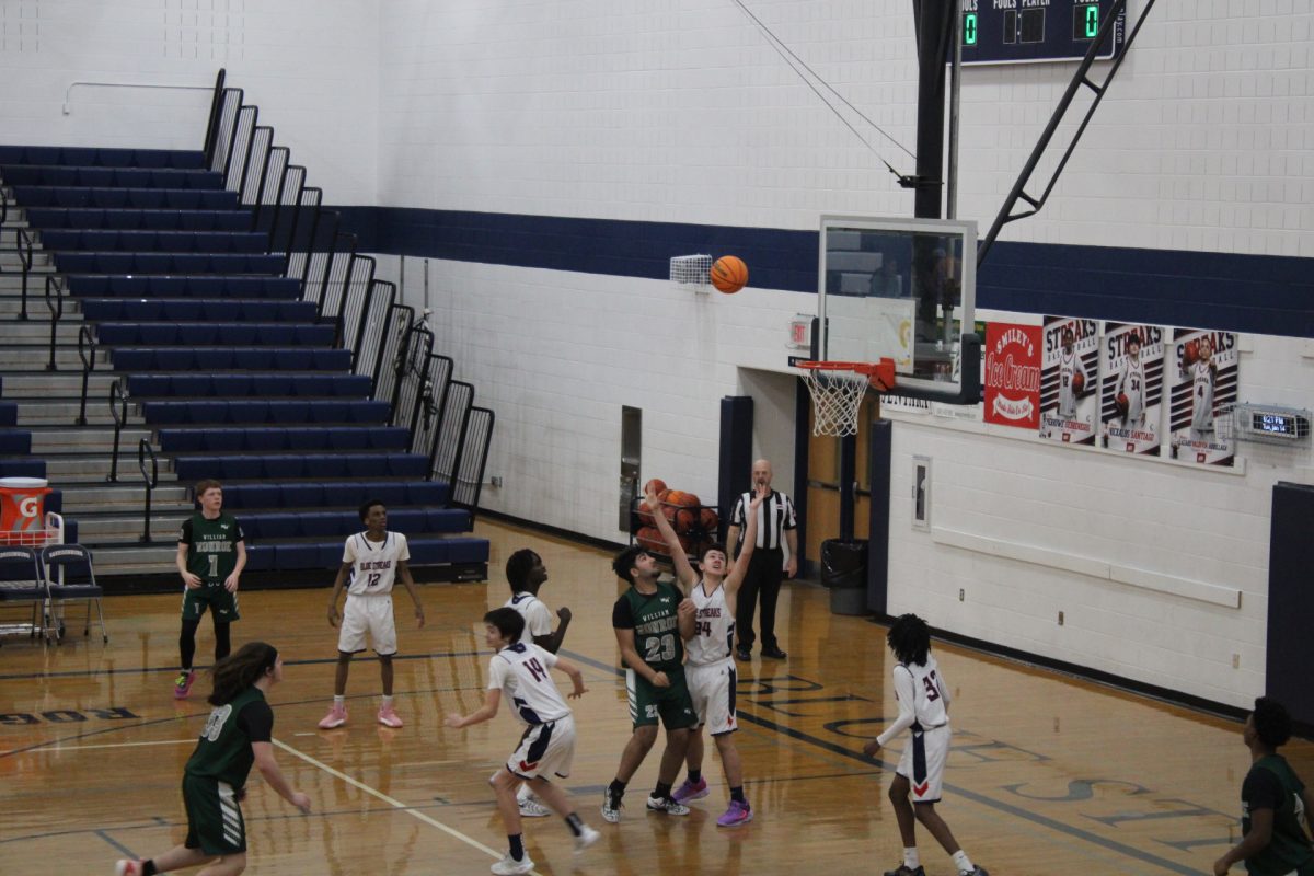 Both Basketball teams play intensely. While William Monroe High School makes a shot at the hoop, Harrisonburg High School basketball team tries to defend and block the ball at all costs.