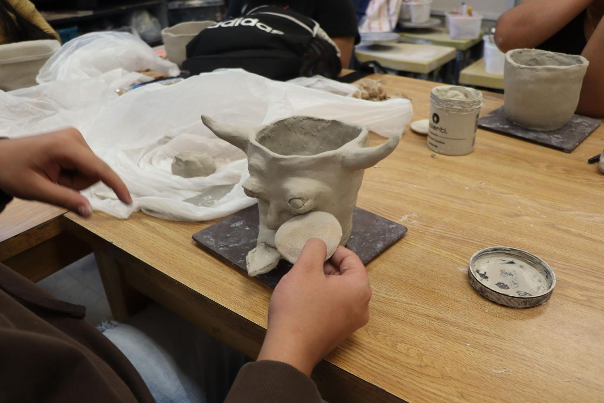 Close up of pottery with a face that has a tongue sticking out.