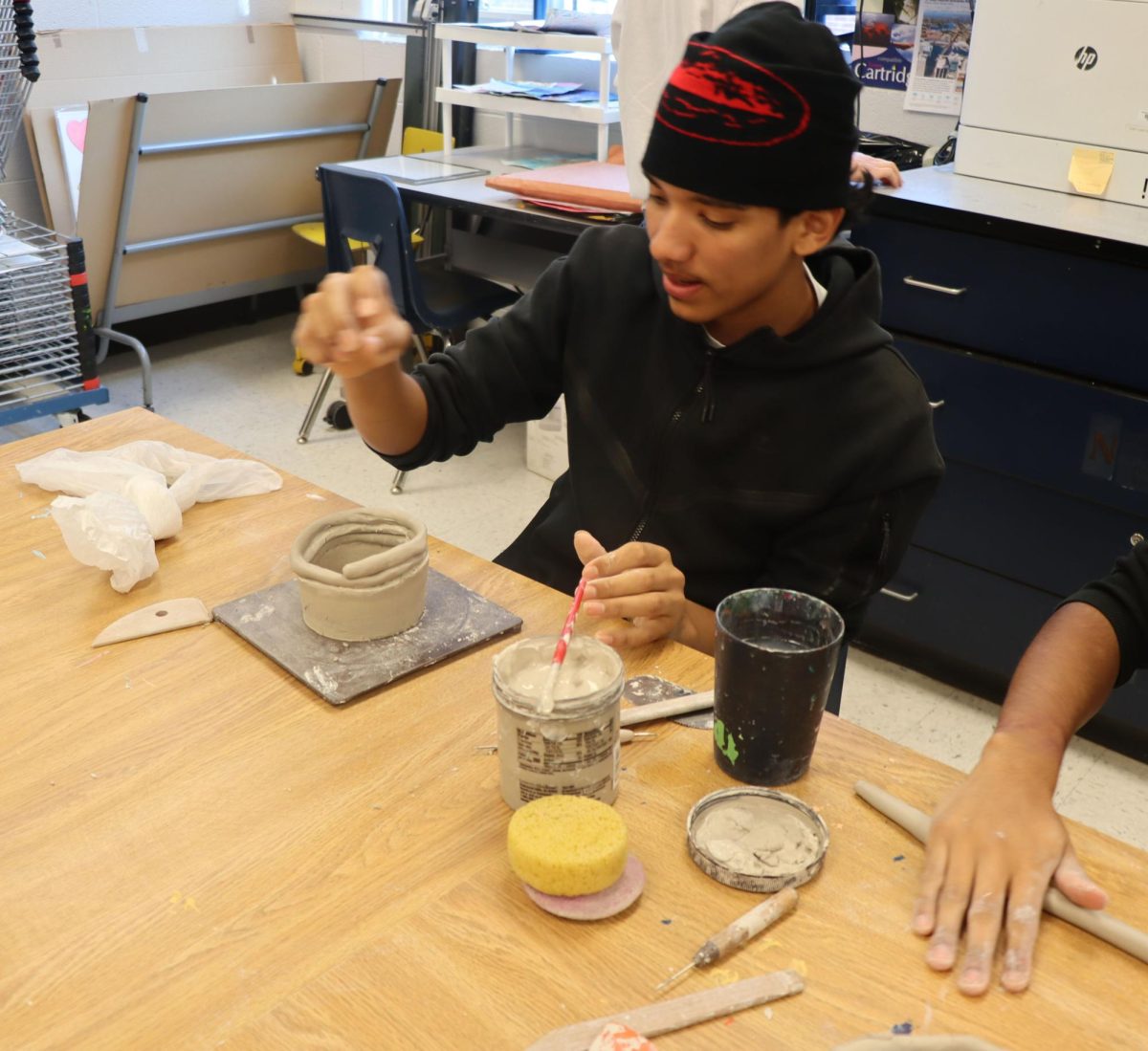 Student locked in on his pottery work.