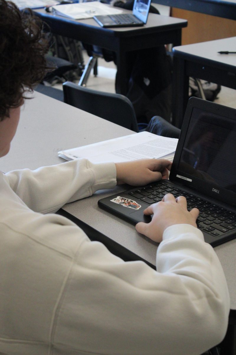 A student turning on his chromebook for his assignment. 