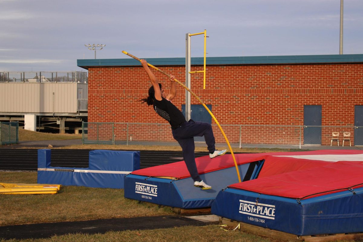 Track athlete practicing pole vault at practice
