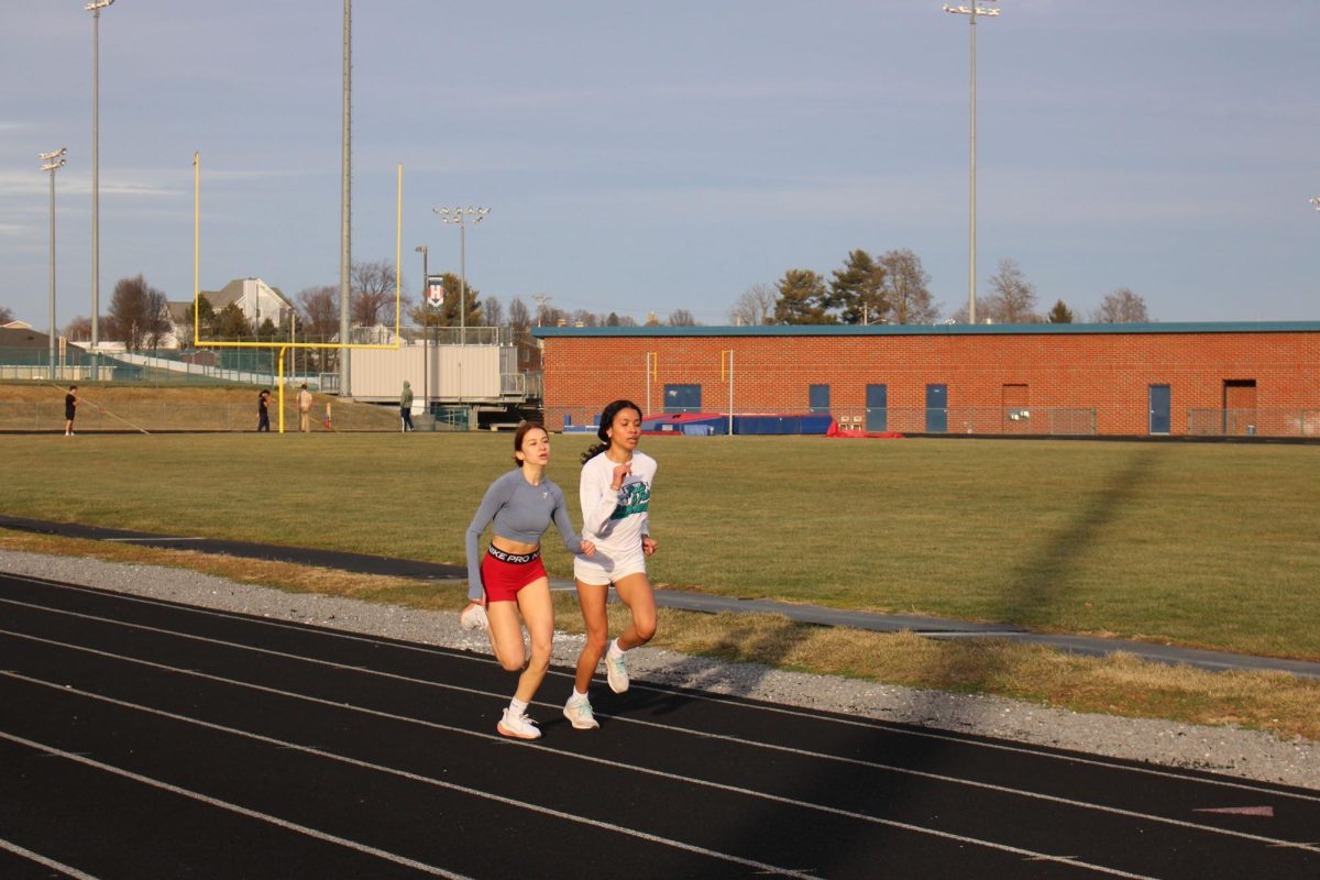 Track athletes Kaycee Tronco-Cordon and Liva Jwanmery running at practice
