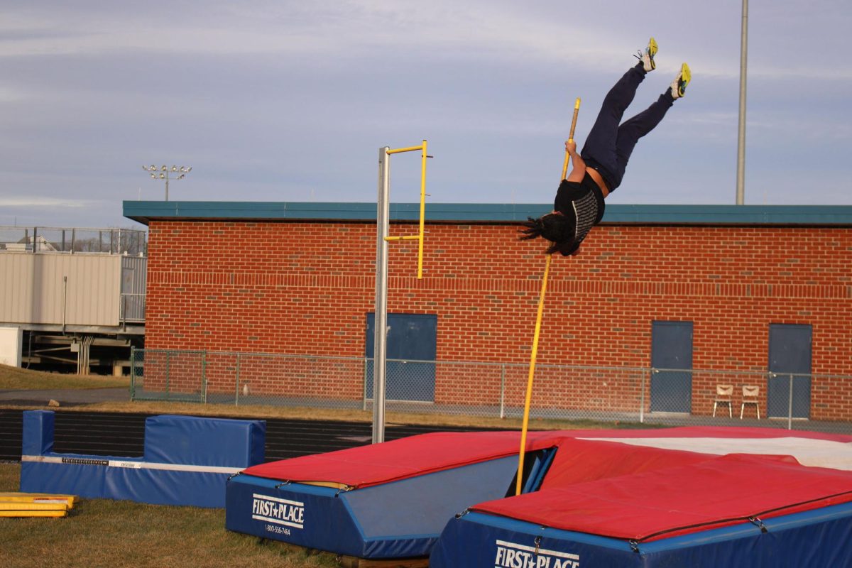 Track athlete practicing pole vault at practice